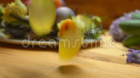 玫瑰花瓣落在桌子上背景是彩色复活节彩蛋视频的预览图