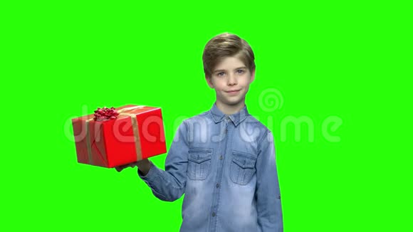 可爱的男孩指着红色的礼盒视频的预览图