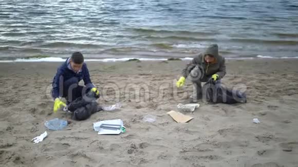 志愿者在海滩上搬运垃圾视频的预览图
