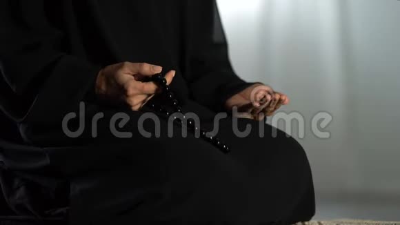 祈祷妇女手中拿着传统的伊斯兰珠子跪在清真寺的地毯上视频的预览图