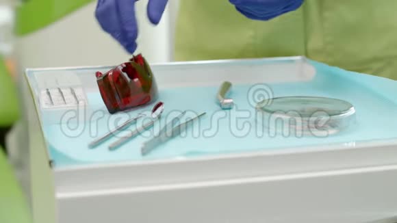 牙医从桌子上拿牙科工具的手口腔镜视频的预览图