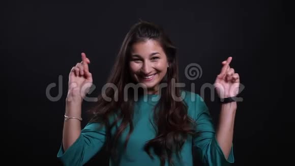 年轻漂亮的黑发女性的特写肖像她的手指交叉着焦虑用相机看着镜头视频的预览图