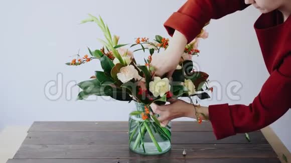 女花匠把花放在玻璃花瓶里做了一个新的花安排从盒子里摘鲜花的女人视频的预览图