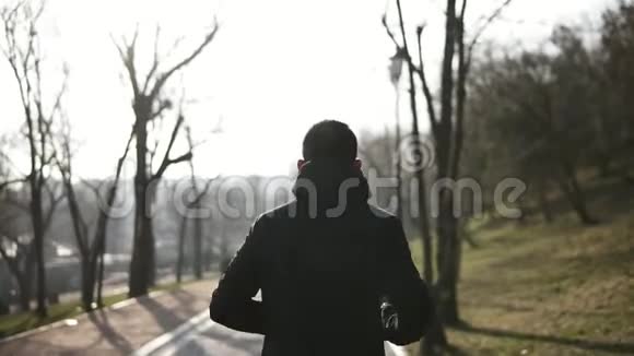 在公园里奔跑的男性形象的背面镜头慢动作视频的预览图