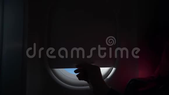 女人的剪影把飞机的窗户递给我从飞机飞机的窗户看到的云彩和天空视频的预览图
