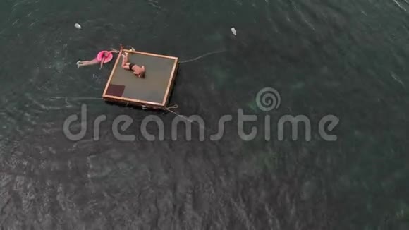 快乐的孩子正从木筏跳入大海空中射击视频的预览图