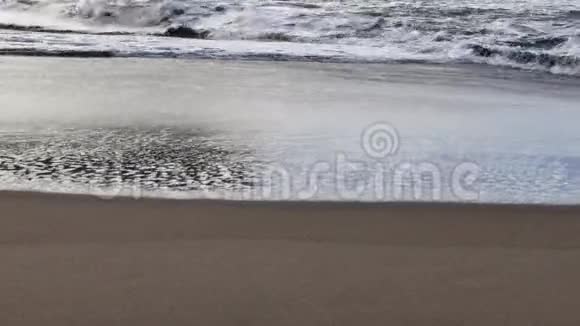 柔软细腻的波浪在光滑的沙滩上流动视频的预览图