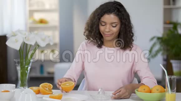 混合种族的年轻女子榨橙汁控制体重和健康视频的预览图