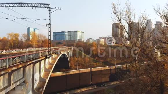 高桥横渡河的航拍镜头无人机飞在桥下迎着秋天的风景视频的预览图