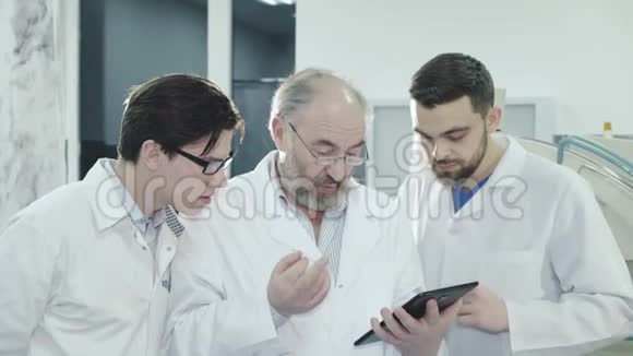 三位男医生讨论一位病人在医院诊断4K视频的预览图