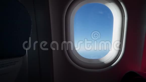 女人的剪影把飞机的窗户递给我从飞机飞机的窗户看到的云彩和天空视频的预览图
