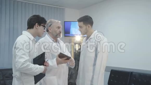 三位男医生讨论一位病人在医院诊断4K视频的预览图