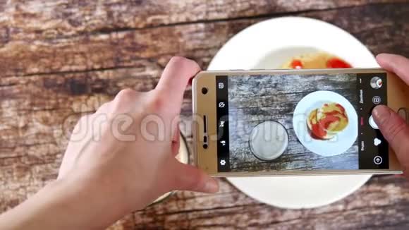 女性手借助智能手机拍摄一份早餐包括一杯卡布奇诺阿拉迪亚女孩是视频的预览图