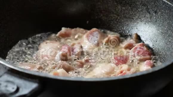 一个年轻女人的手在锅里用猪肉炒视频的预览图