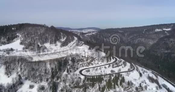 鸟瞰自然景观冬天的道路旅行雪穿过通道的道路视频的预览图