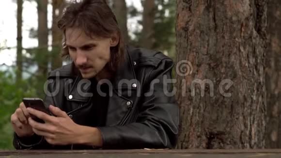 他坐在树林里拿着电话视频的预览图