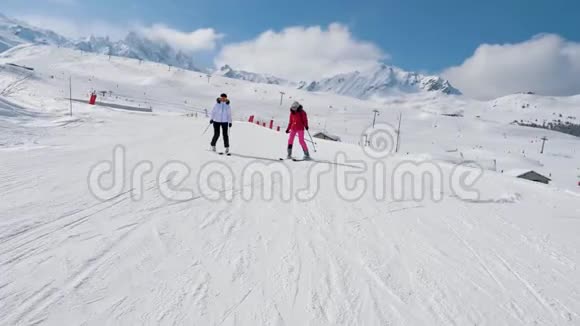 两名女子滑雪者滑下冬天山的理想斜坡视频的预览图