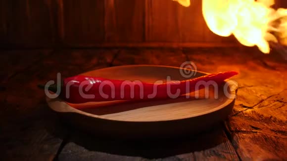 在木桌上的木盘里放着红辣椒在木桌上喷着火焰视频的预览图