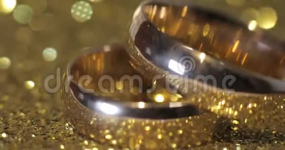 婚礼戒指躺在闪亮的光泽表面光芒四射特写视频的预览图
