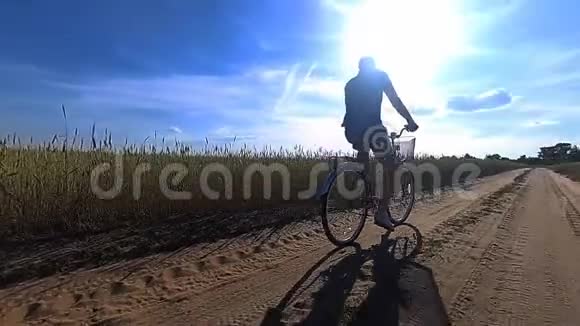 夏天一个年轻人骑着自行车在一片麦田的中央视频的预览图