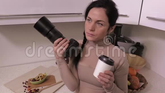 带专业相机的女士在厨房放松和喝咖啡视频的预览图