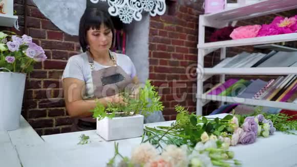花艺设计工作室花艺师在木盒中整理花艺视频的预览图