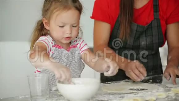 幸福的爱的家庭正在一起准备面包母亲和孩子的女儿在做烹饪和娱乐视频的预览图