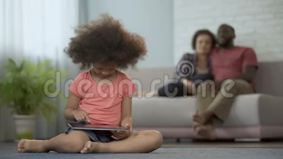 父母自豪地观察他们的女儿如何在平板电脑上工作神童视频的预览图