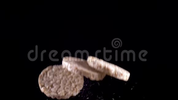 三个米饭和玉米面包在黑色背景上飞起来慢动作视频的预览图