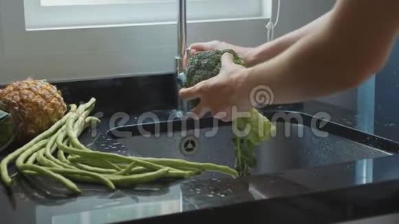 贴身女人她在家庭厨房慢动作地洗花椰菜视频的预览图