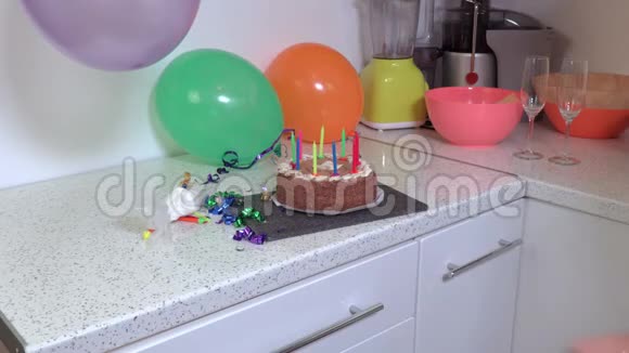 女人拿生日派对蛋糕离开厨房视频的预览图