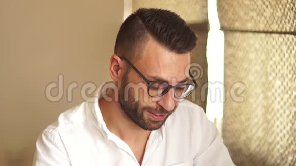 一位戴着眼镜和一件白色衬衫的迷人商人的肖像一个男人透过眼镜看着他的笑容视频的预览图