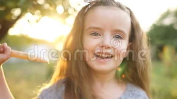 夏日里草地上快乐的小女孩长发婴儿笑着张开嘴婴儿的牙齿是可见的视频的预览图