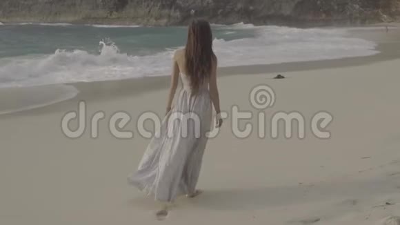 穿着长裙的女人走在沙滩上留下脚印视频的预览图
