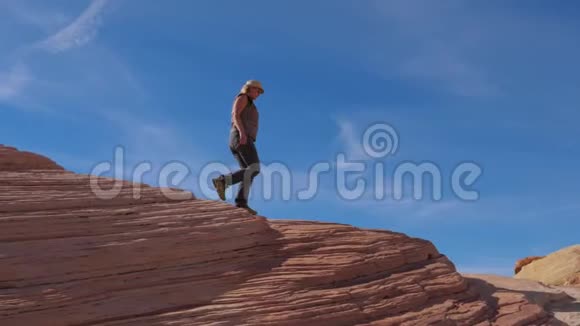 旅游妇女徒步下山与五颜六色的红岩慢动作4K视频的预览图