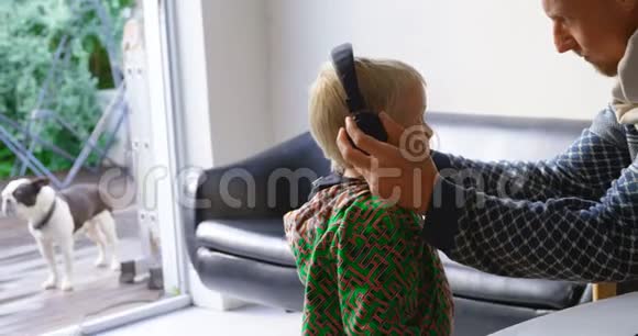 父子俩用耳机听音乐视频的预览图