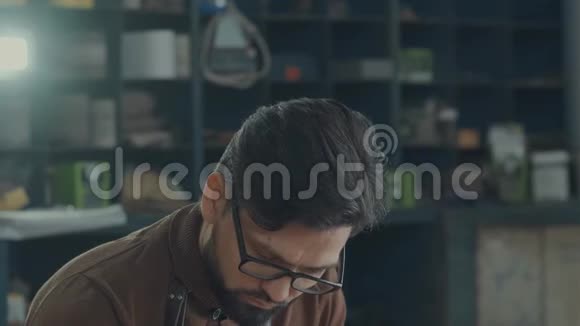 一个带眼镜胡子和工作围裙的黑发男人的肖像视频的预览图