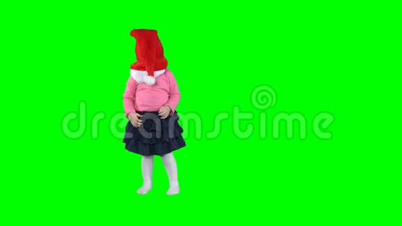 顽皮的小女孩摘下圣诞老人的帽子把自己孤立地扔在绿色上视频的预览图