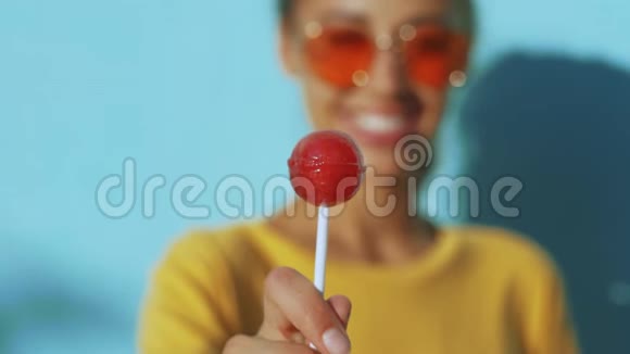 一个年轻的晒黑笑女人的脸特写带着红色眼镜的开朗微笑的女人站在蓝边视频的预览图