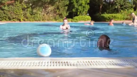 一个年轻女孩在室外游泳池里玩球视频的预览图