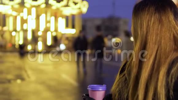 留着长发的漂亮女人欣赏旋转木马和咖啡视频的预览图