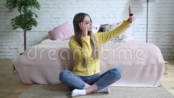 开朗迷人的年轻女性在家用手机自拍视频的预览图