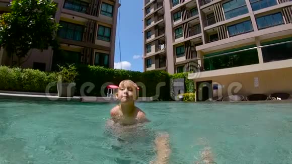 一个小男孩在游泳池里泼水的慢镜头视频的预览图