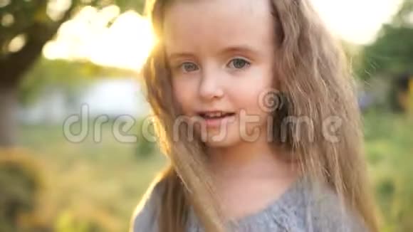 小女孩在周围乱晃摇摇头和头发把头发从脸上移开这孩子很快乐特写视频的预览图