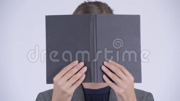 年轻女商人的脸在用书遮脸时思考视频的预览图