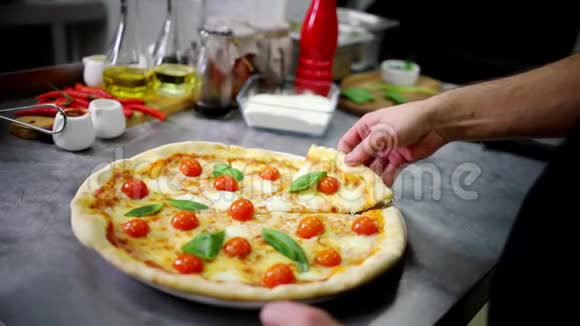 餐厅厨房厨师拿一块凯撒披萨视频的预览图
