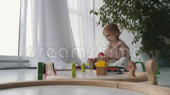 金发小女孩玩木玩具视频的预览图