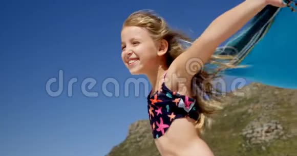 沙滩上玩毯子的女孩视频的预览图