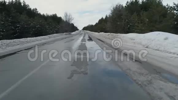 沥青路穿过松林冬季林道交通冬季森林空中勘测视频的预览图