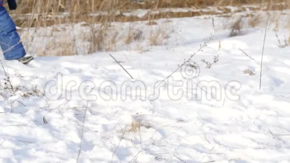 一个孩子在新鲜的雪上玩耍在图片中只能看到穿靴子的腿视频的预览图